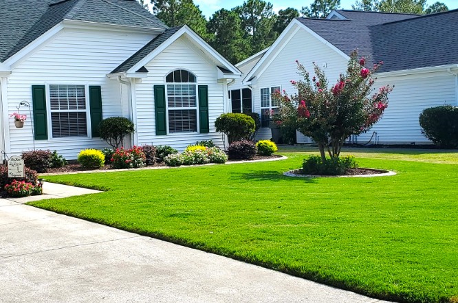 Manicured front yard white ranch home flower beds — Conway SC